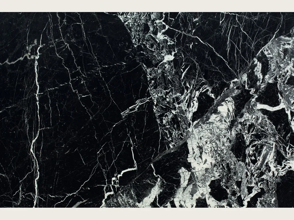 Placa de mármol negro Grand Antique: negro profundo con vetas blancas finas y una zona densa de fragmentos blancos rotos