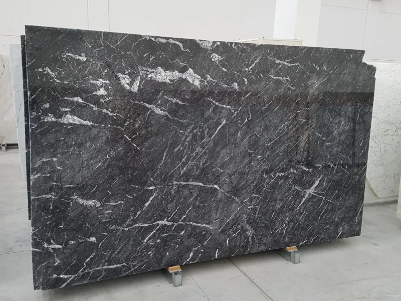 Placa de mármol negro Grigio Carnico: fondo negro grisáceo con vetas blancas ramificadas y red gris tenue (otra placa)