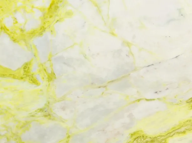 Detalle del Mármol Luminous: veta amarillo limón intensa sobre el fondo blanco azulado
