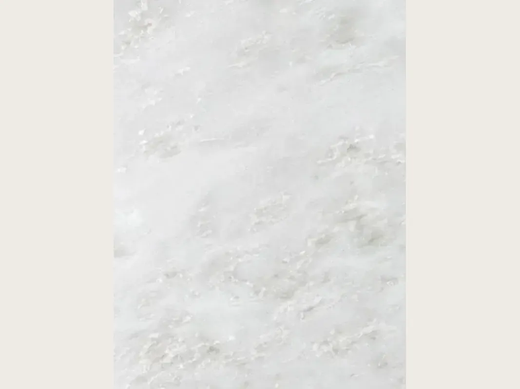 Placa de mármol blanco Namibia Cream: fondo blanco grisáceo casi liso con nubes grises tenues en diagonal