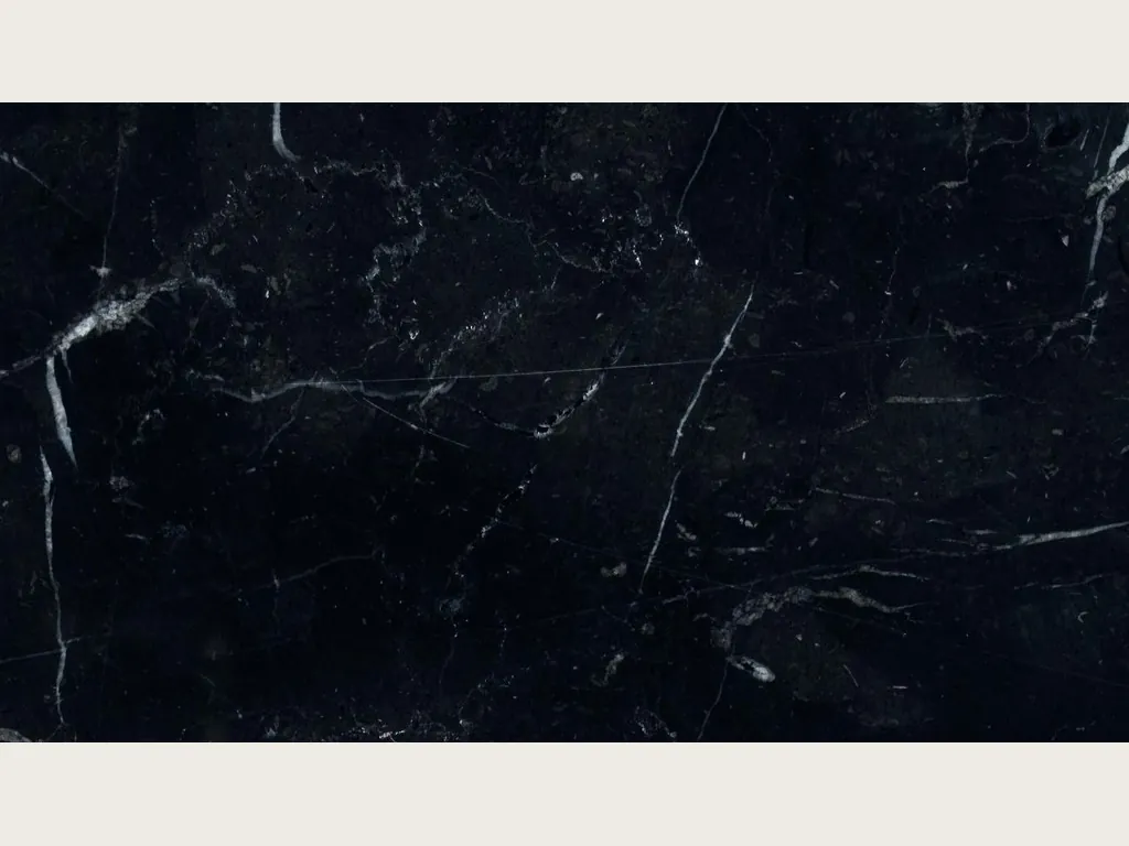 Placa de mármol negro Nero Marquina: fondo negro profundo con pocas vetas blancas finas y rectas en diagonal (otra placa)