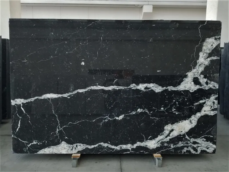 Placa de mármol negro Nero Marquina: fondo negro profundo con pocas vetas blancas finas y rectas en diagonal (otra placa)