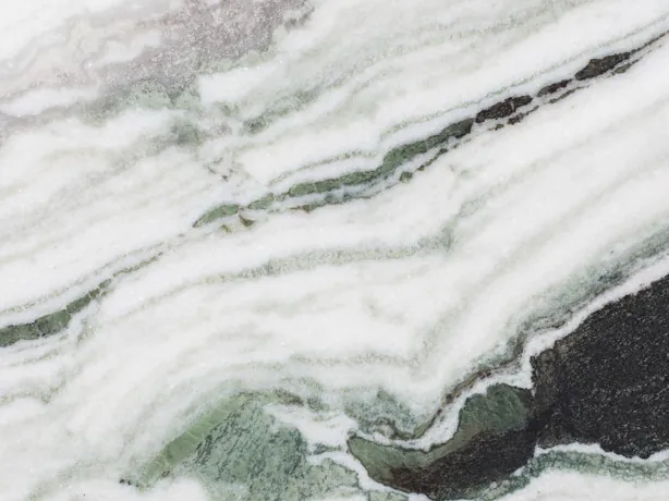 Detalle del Mármol Panda White: bandas negras gruesas y toques verdes sobre el blanco