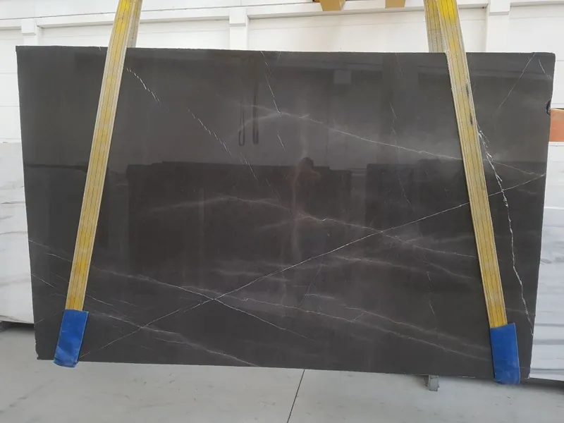 Placa de mármol gris Pietra Grey: fondo gris oscuro con vetas finas de gris claro en diagonal