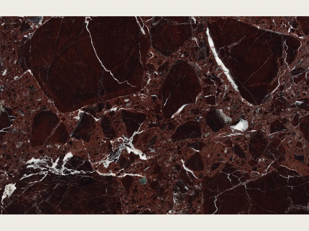 Placa de mármol rojo Rosso Lepanto: fragmentos rojo intenso separados por una red densa de vetas blancas (otra placa)