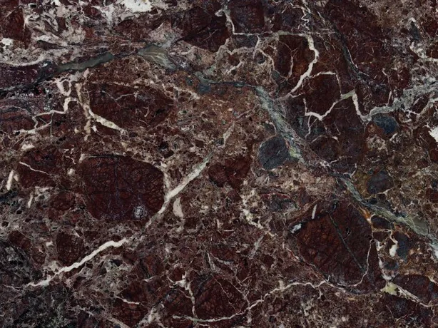 Detalle del Rosso Levanto: la red de vetas blancas finas entre fragmentos burdeos y zonas verde grisáceo