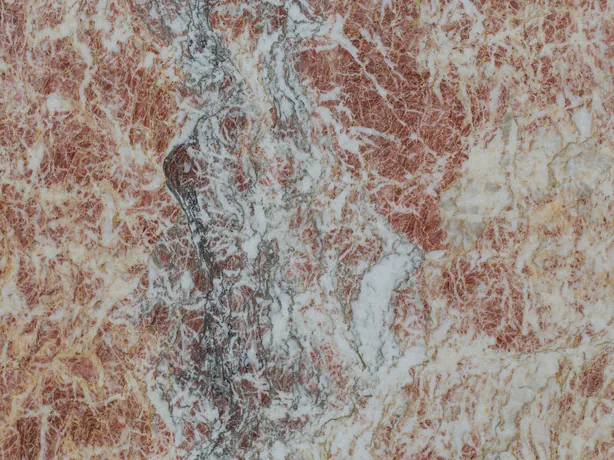 Detalle del Mármol Rosa Peralba: la red de vetas blancas finas sobre el rosa rojizo
