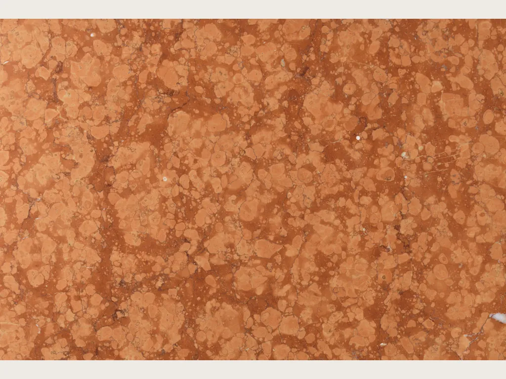 Placa de mármol rojo Rosso Verona: fondo rojo violáceo con nubes beige y dos vetas blancas verticales (otra placa)
