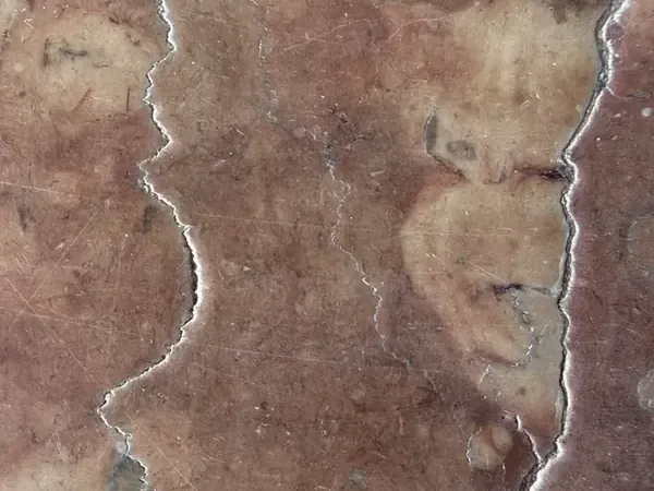 Placa de Mármol Rosso Verona: fondo rojo violáceo con nubes beige y dos vetas blancas verticales