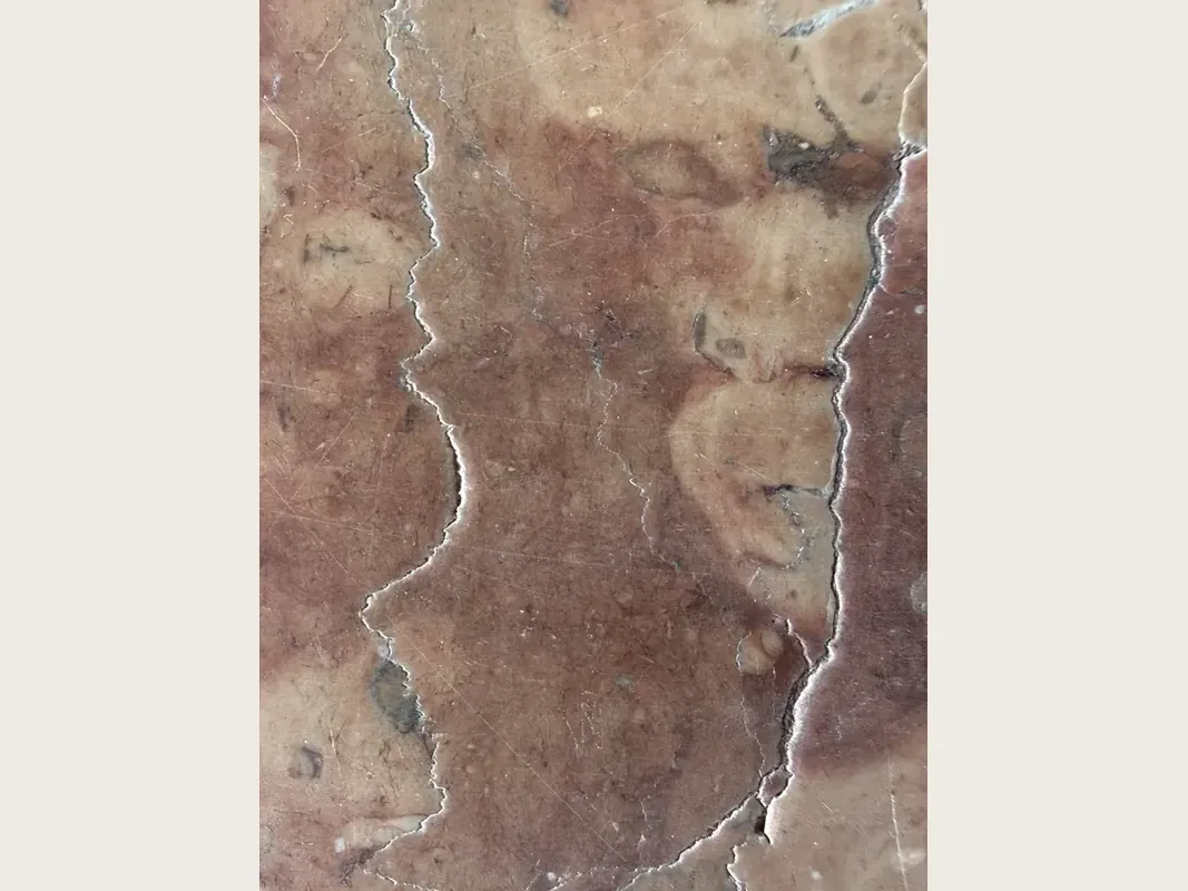 Placa de mármol rojo Rosso Verona: fondo rojo violáceo con nubes beige y dos vetas blancas verticales