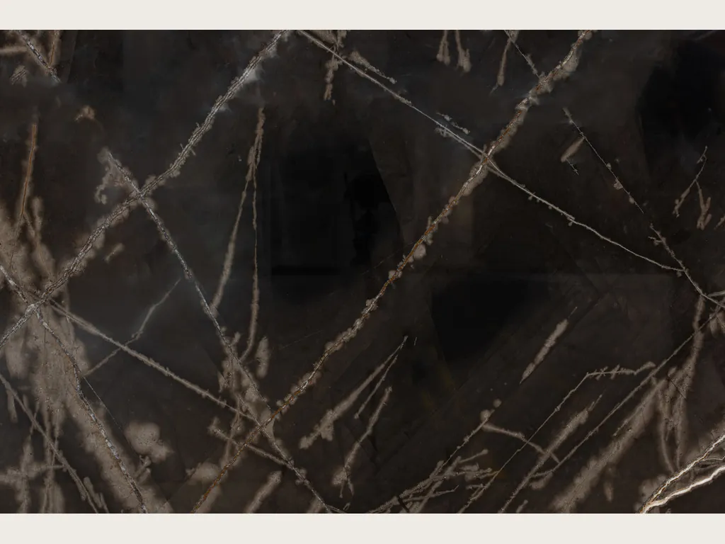 Placa de mármol negro Sahara Bronze: fondo negro amarronado con trazos bronce finos que se cruzan
