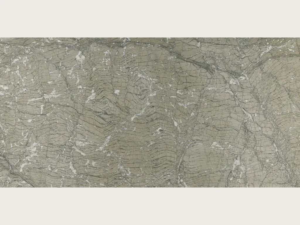 Placa de Mármol Verde Antigua: fondo gris verdoso con líneas onduladas gris oscuro y fragmentos blancos dispersos