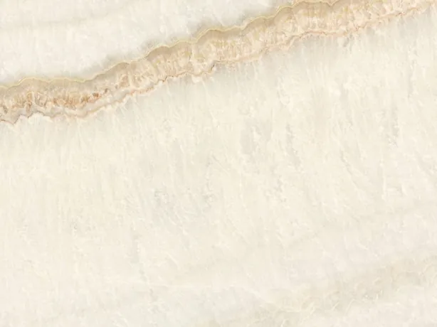 Detalle del Ónix Ivory: bandas suaves en diagonal y la línea miel fina sobre el marfil