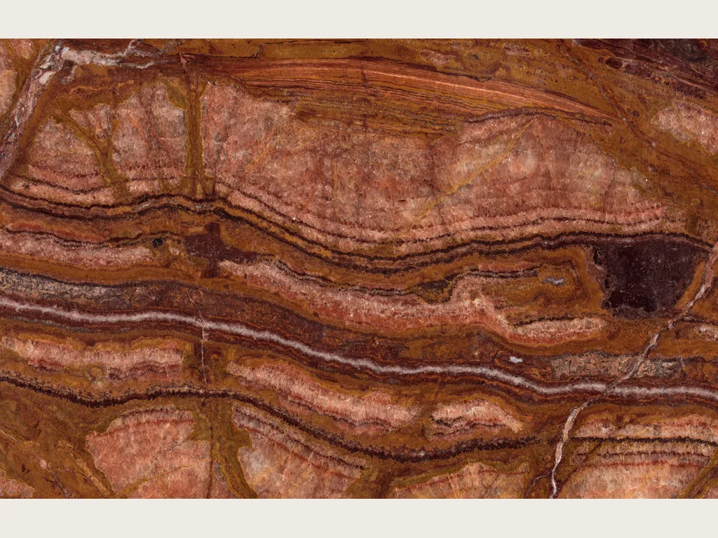 Placa de Ónix Rojo: fondo rojo óxido con manchas irregulares rojo oscuro y naranja y una zona ocre verdosa (otra placa)