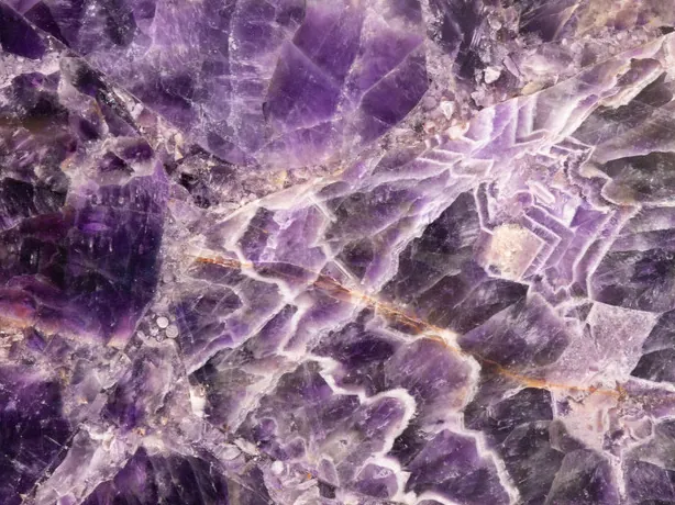 Detalle de amatista: franjas en zigzag entre cristales violeta, pulido brillante