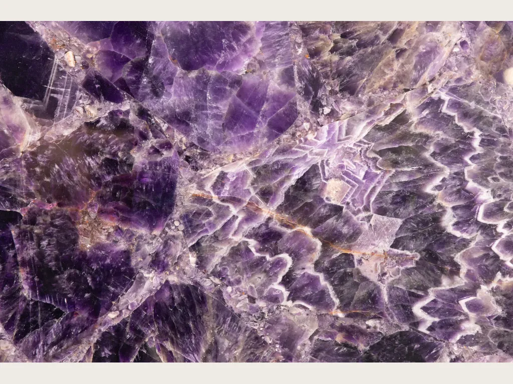 Placa de amatista: cristales violeta oscuro con franjas blancas y lilas en zigzag