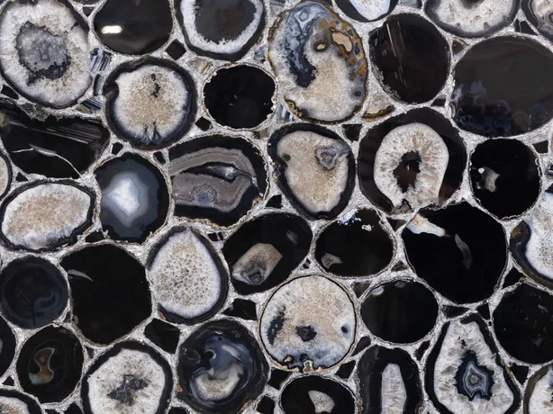 Detalle del Ágata Negra con Hoja de Plata: anillos grises y blancos de las rodajas y juntas plateadas con el brillo del pulido