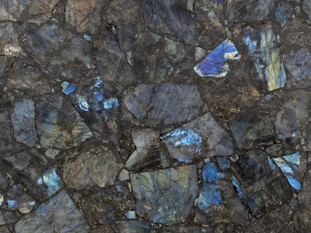 Detalle de la labradorita: destellos azules iridiscentes sobre piezas grises