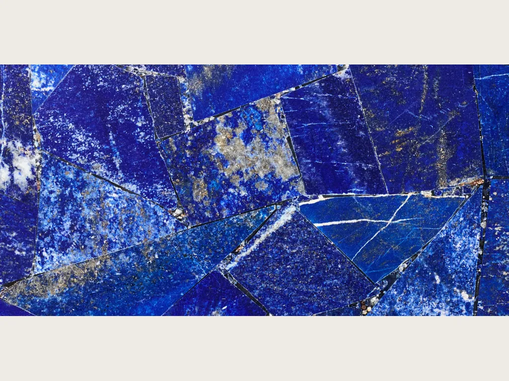 Placa de lapislázuli: mosaico de piezas angulosas azul ultramar con motas blancas y puntos dorados