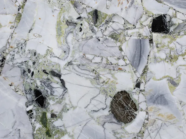 Detalle de la placa de White Beauty: matriz verde claro y líneas grises finas entre fragmentos pulidos