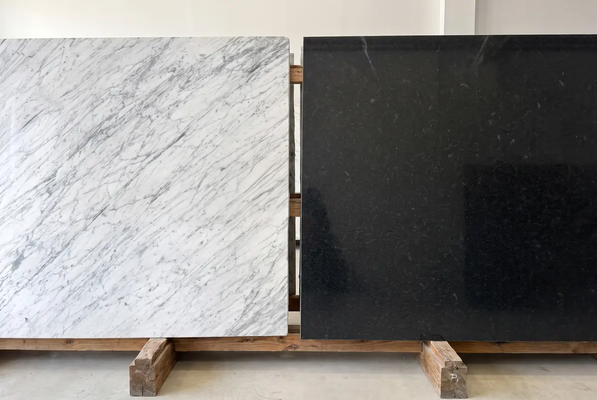 Una placa de mármol blanco y una de granito negro, una al lado de la otra con la misma luz