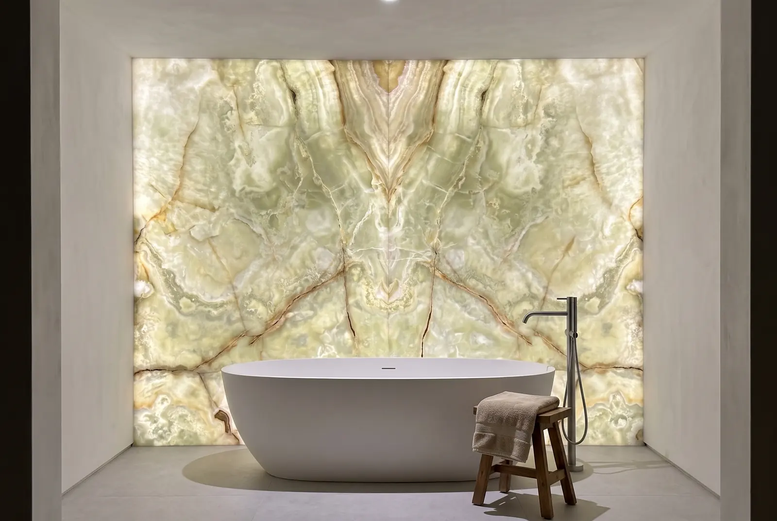 Pared de baño de Ónix Verde retroiluminado detrás de una bañera exenta